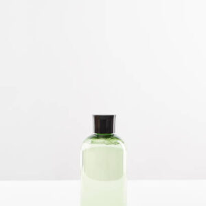 Transparent cosmetic bottle with tonic on white background with copy space